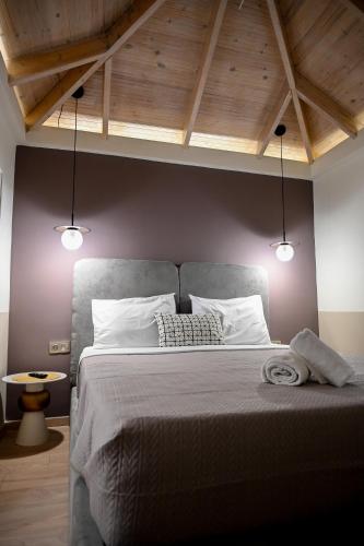 a bedroom with a large bed with two lights at ΜΕΛΑΝΘΙΑ m5 in Preveza