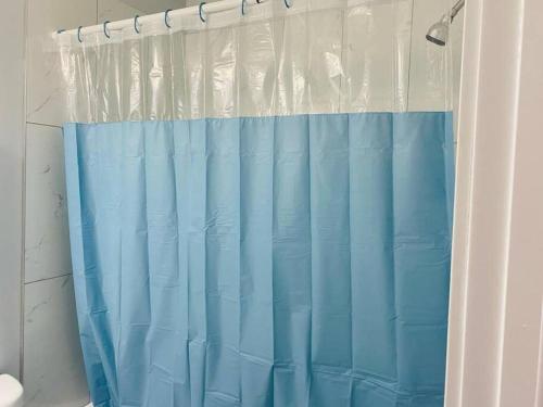 a blue shower curtain in a bathroom at Olive Place in Saskatoon