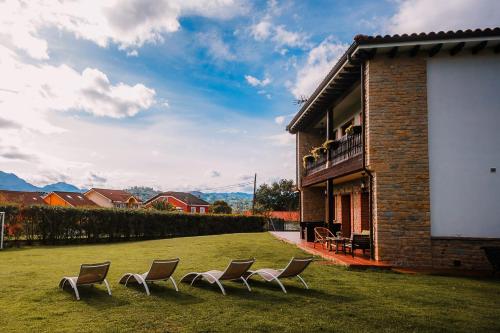 un groupe de chaises assises dans une cour à côté d'un bâtiment dans l'établissement Villa Tiviti, à Oviedo