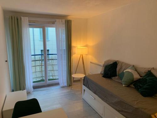 salon z łóżkiem, stołem i oknem w obiekcie Appartement tout équipé à 6 minutes de la Gare St Charles w Marsylii