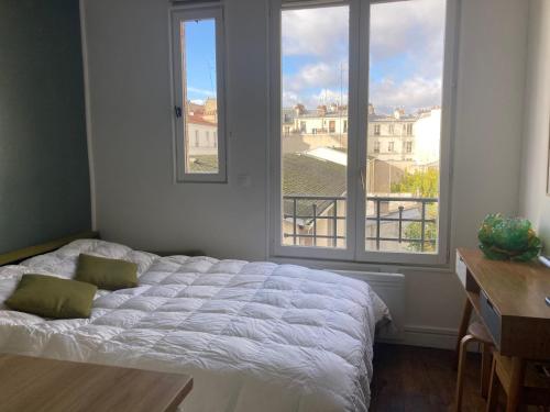 une chambre avec un lit et une grande fenêtre dans l'établissement Jupiter 101 Studio Montmartre, à Paris