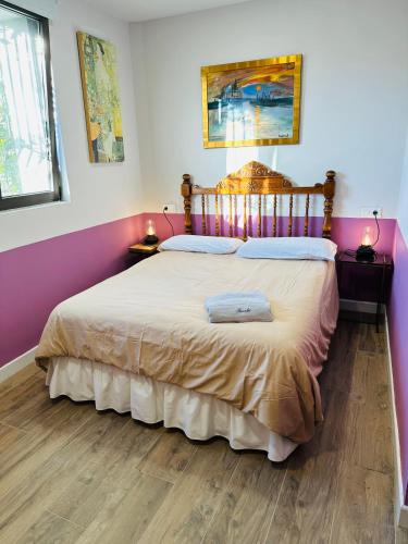 a bedroom with a large bed with pink walls at ROSALES Apartamento y jardín in Oviedo