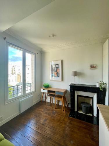 un salon avec une table et une cheminée dans l'établissement Jupiter 101 Studio Montmartre, à Paris