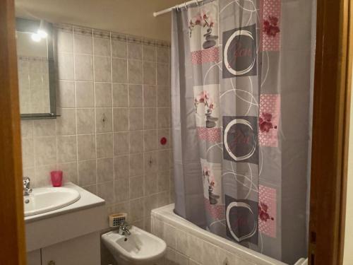a bathroom with a shower curtain and a sink at Maison familiale au cœur d’un village typique in Alba-la-Romaine