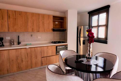 a kitchen with a table and chairs and a refrigerator at Apartamento 307 - Vista a la Represa - 1 Habitación y Sofa Cama - Rentas Cortas Gerencial in Guatapé