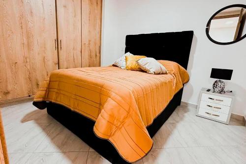 a bedroom with a bed with an orange blanket at Apartamento 307 - Vista a la Represa - 1 Habitación y Sofa Cama - Rentas Cortas Gerencial in Guatapé