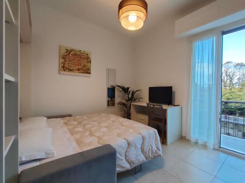 a bedroom with a bed and a tv and a window at Casa Ewa - Centro Pesaro in Pesaro