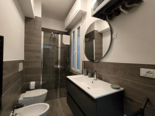 a bathroom with a sink and a toilet and a mirror at Casa Ewa - Centro Pesaro in Pesaro