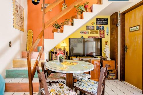 comedor con mesa, sillas y escaleras en Casa Hostel Mosaicos DyA, en Florianópolis