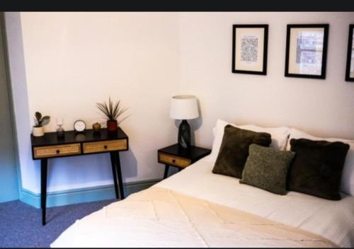 a bedroom with a bed and a table with a lamp at The White Hart in King's Lynn