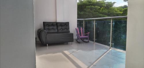 a black leather chair sitting on a balcony at La Reserva de UBA in El Socorro