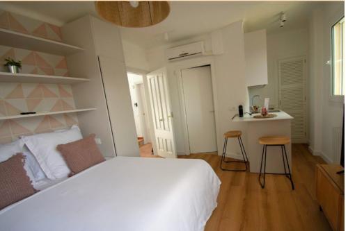 um quarto com uma cama branca e uma mesa em Lavendel Apartments em Colonia Sant Jordi