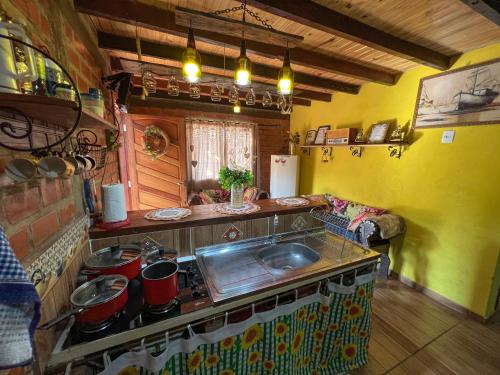a kitchen with a sink and a counter top at Pousada Tarumã challes 01 in Bonito