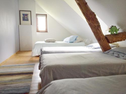 Cette chambre mansardée comprend 3 lits. dans l'établissement Le Petit Manoir de la Vernelle, à Fourmetot