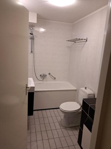 een badkamer met een bad, een toilet en een wastafel bij 't Klèène Genot in Hollum