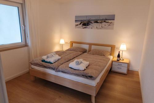 een slaapkamer met een bed met twee handdoeken erop bij Ferienwohnung MEHLBAUM in Albstadt