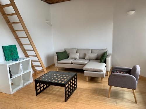 sala de estar con sofá y silla en Appartement vue sur Meuse en Namur