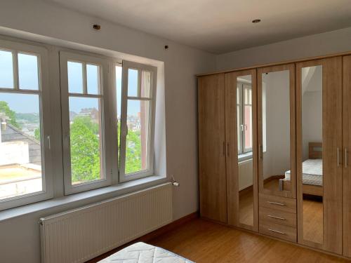 une chambre avec fenêtres et une chambre avec une autre chambre dans l'établissement Appartement vue sur Meuse, à Namur