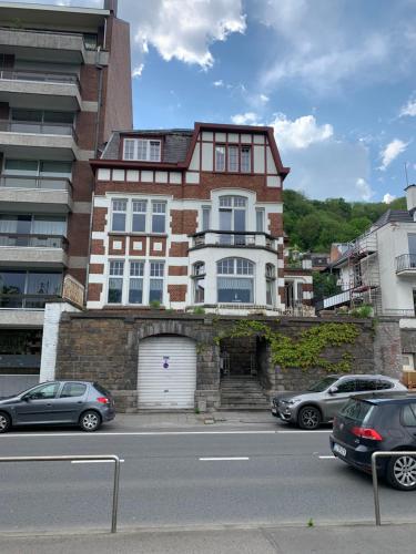 un bâtiment avec une porte blanche et des voitures garées dans la rue dans l'établissement Appartement vue sur Meuse, à Namur