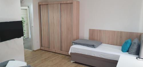 um pequeno quarto com uma cama e uma televisão em Apartmani Stara Skola 