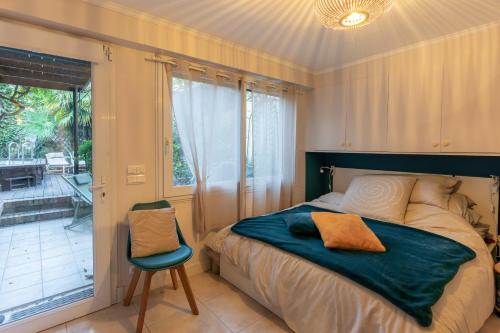 um quarto com uma cama, uma cadeira e uma janela em Maison avec piscine - Vincennes em Vincennes