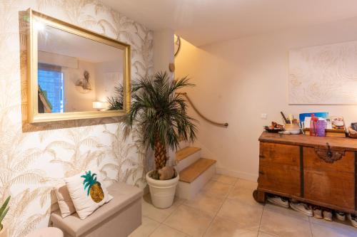 uma casa de banho com um WC, um espelho e uma planta em Maison avec piscine - Vincennes em Vincennes