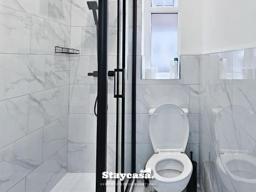 biała łazienka z toaletą i prysznicem w obiekcie Astonishing 6 Bedroom 4baths House w Manchesterze