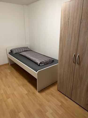 een bed in een kamer naast een houten kast bij Home in Lahr