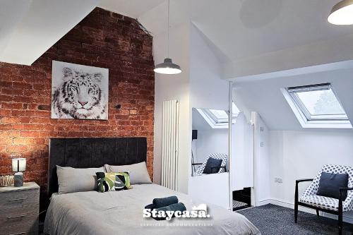 a bedroom with a bed and a brick wall at Astonishing 6 Bedroom 4baths House in Manchester