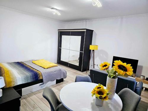 una camera da letto con un letto e un tavolo con girasoli di Concept Urban a Mediaş