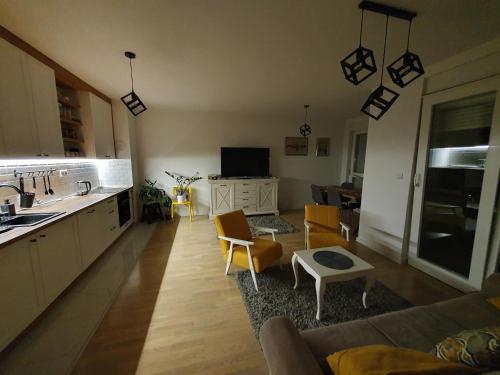 a kitchen and living room with a couch and a table at Apartment Noa in Tuzla