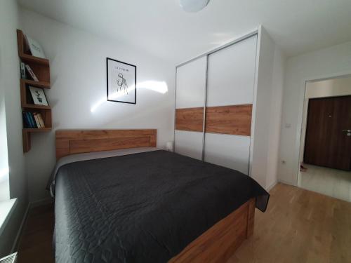 1 dormitorio con 1 cama con edredón negro en Apartment Noa en Tuzla