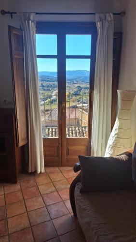 a room with a large glass door with a view at Apartamentos La Morada del Cura in Fuentespalda