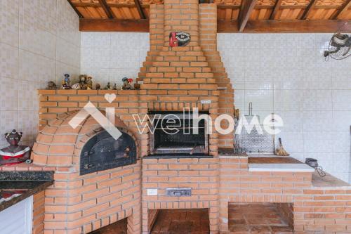um forno de tijolos ao ar livre numa cozinha com um balcão em Casa com ampla área verde e piscina em Itupeva em Itupeva