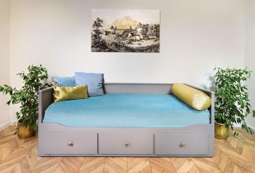 Bett in einem Zimmer mit zwei Topfpflanzen in der Unterkunft Bonton Apartments in Kežmarok
