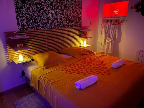 a bedroom with a bed with two pillows on it at Maison avec Jacuzzi - Louvres proche Roissy CDG - Paris in Louvres