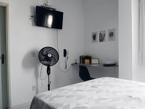 um quarto com uma cama, uma secretária e uma ventoinha em Apartamento Completo A25 Flat Centro em Mogi das Cruzes