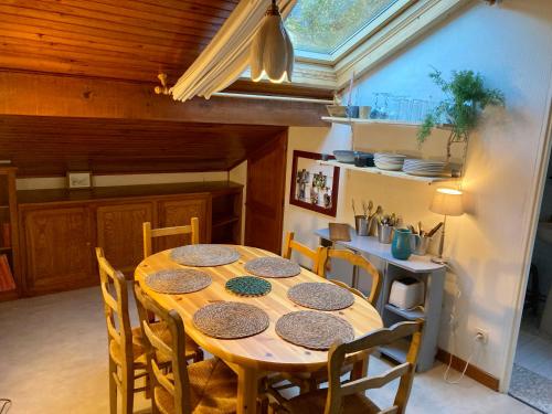 a dining room with a wooden table and chairs at Chez papa et maman in Eaux-Bonnes