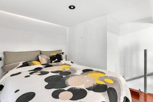 een slaapkamer met een bed met een zwart en geel dekbed bij DF MiniLOFT, Milano-SanSiro in Milaan