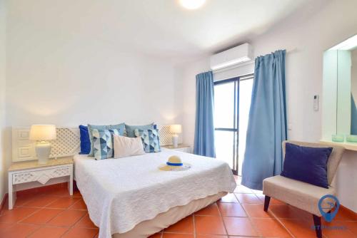 1 dormitorio con 1 cama grande y 1 silla en Balaia Golf by MTPhomes, en Albufeira