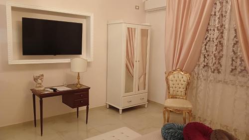 un salon avec une chaise, un bureau et une télévision dans l'établissement Le 3 Dee, à Reggio de Calabre
