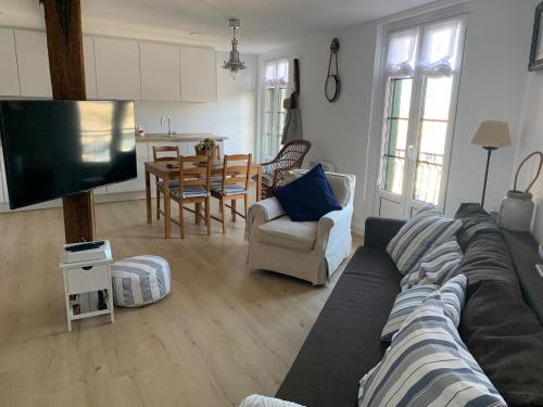 ein Wohnzimmer mit einem Sofa, einem TV und einem Tisch in der Unterkunft ISTUA - Etxie La Casa in Bermeo