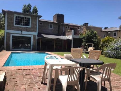 d'une terrasse avec une table et des chaises à côté de la piscine. dans l'établissement Mi Bella Vista - Quinta Con Pileta, à Bella Vista
