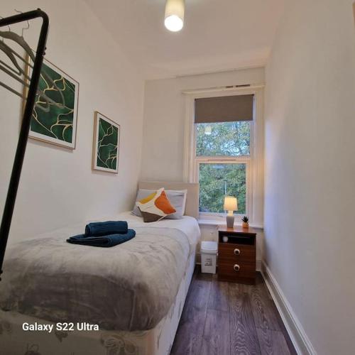 ein kleines Schlafzimmer mit einem Bett und einem Fenster in der Unterkunft 4 Bed Park View House-Free Parking - Sleep 8 in Plymouth