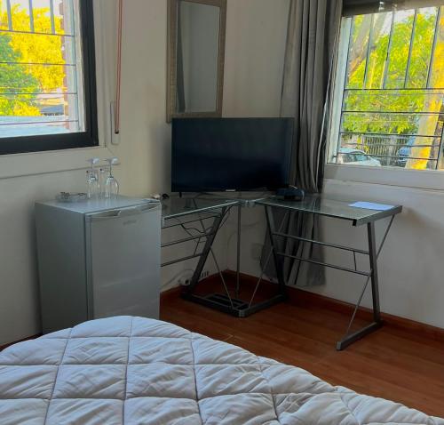1 dormitorio con escritorio, ordenador y cama en Habitacion en Carrasco, cerca del aeropuerto, en Montevideo