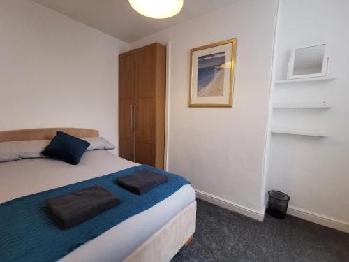 a bedroom with a bed with two pillows on it at Cosy One Bedroom Apartment in Exeter