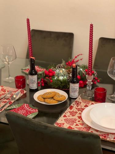 a table with a plate of cookies and wine bottles at Urban City Center in Tirana