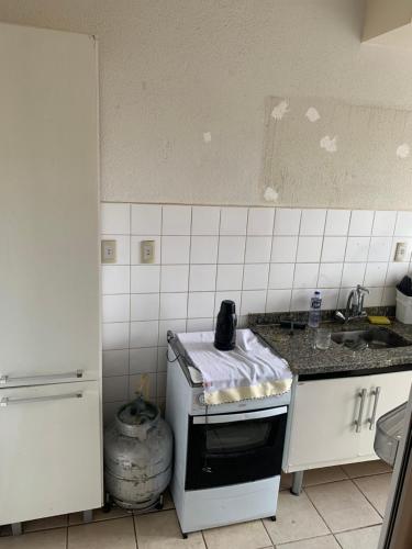 a kitchen with a stove and a sink at Apartamento funcional in Varginha