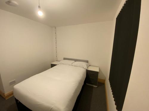 a small bedroom with a white bed in a room at Spacious 4BR Close to Digbeth in Birmingham