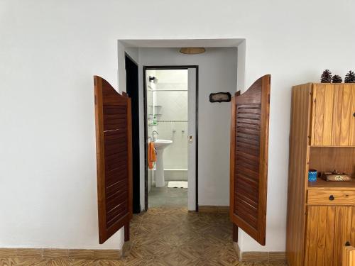 a bathroom with two open doors and a sink at La casa de Chola in Playa Unión